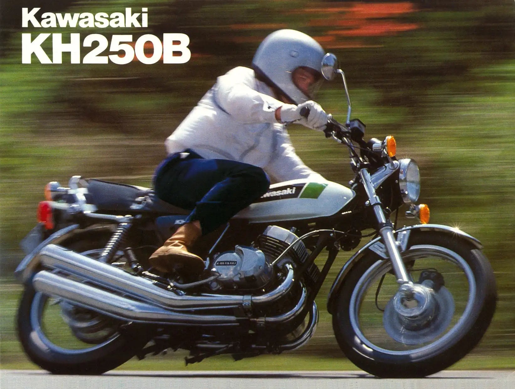 White and green kawasaki kh250b motorcycle with chrome exhaust pipes and black seat.