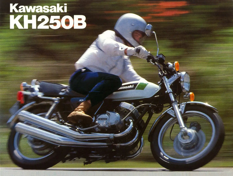 White and green kawasaki kh250b motorcycle with chrome exhaust pipes and black seat.